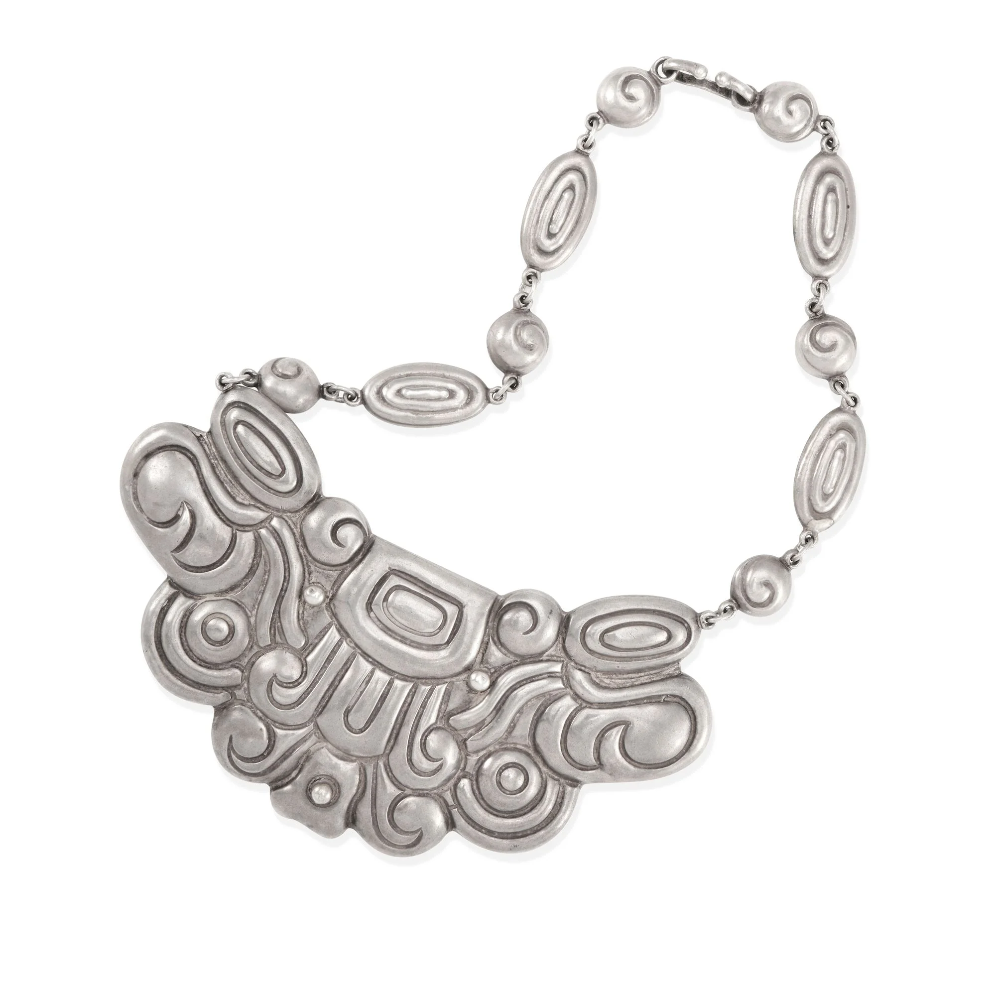A Los Castillo silver necklace, circa 1940, with a heavily worked pre-Columbian-motif bib pendant supported by oval spiral-motif links. Sold for $7,040 at Bonhams, June 2023.