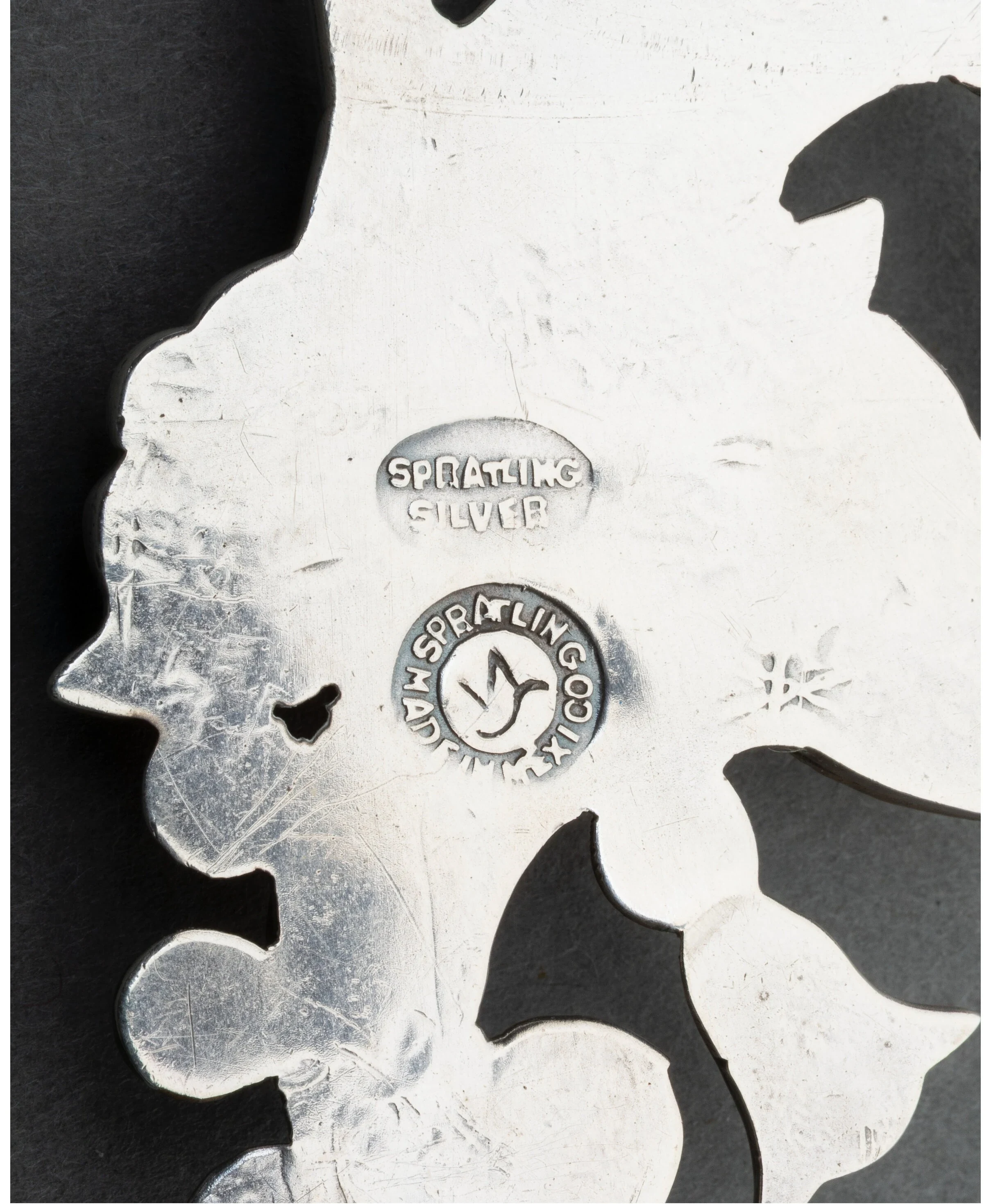 William Spratling's circa-1940 hallmarks on the reverse of the Tree of Life pin: an oval SPRATLING SILVER stamp above the circular WS bird cartouche ringed WM SPRATLING MADE IN MEXICO.